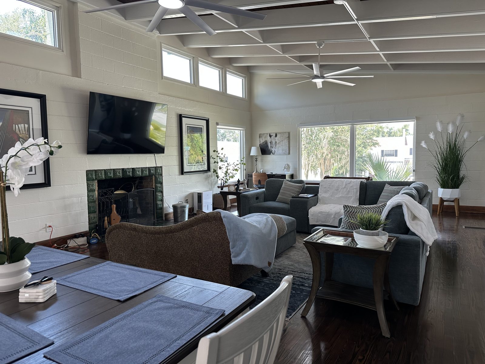 The living room fireplace and 75-inch screen under clerestory windows