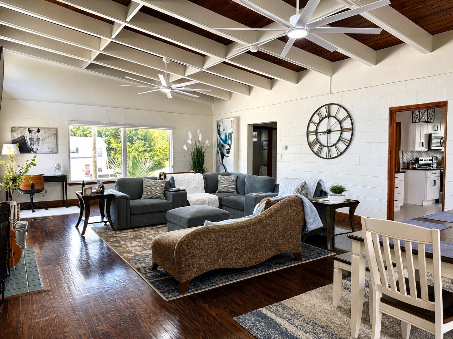 The open living and dining area under a beamed cathedral ceiling in stained wood