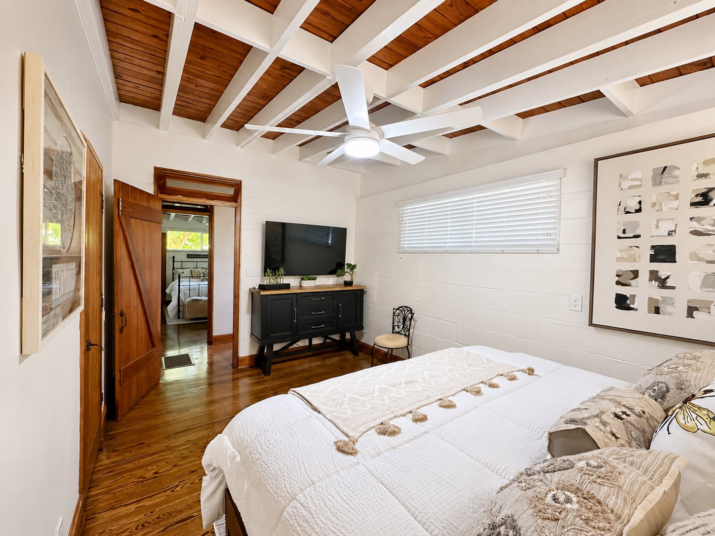 The main bedroom, with television, dresser and a beamed wood ceiling